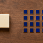 One large block sits beside sixteen small tiles arranged in a four-by-four grid